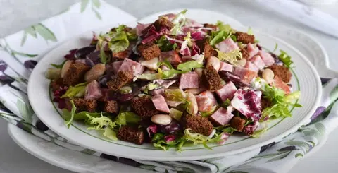 Салат с фасолью, копченой колбасой и сухариками